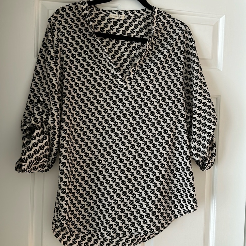 Black and cream v-neck blouse with roll up button sleeves. Runs big